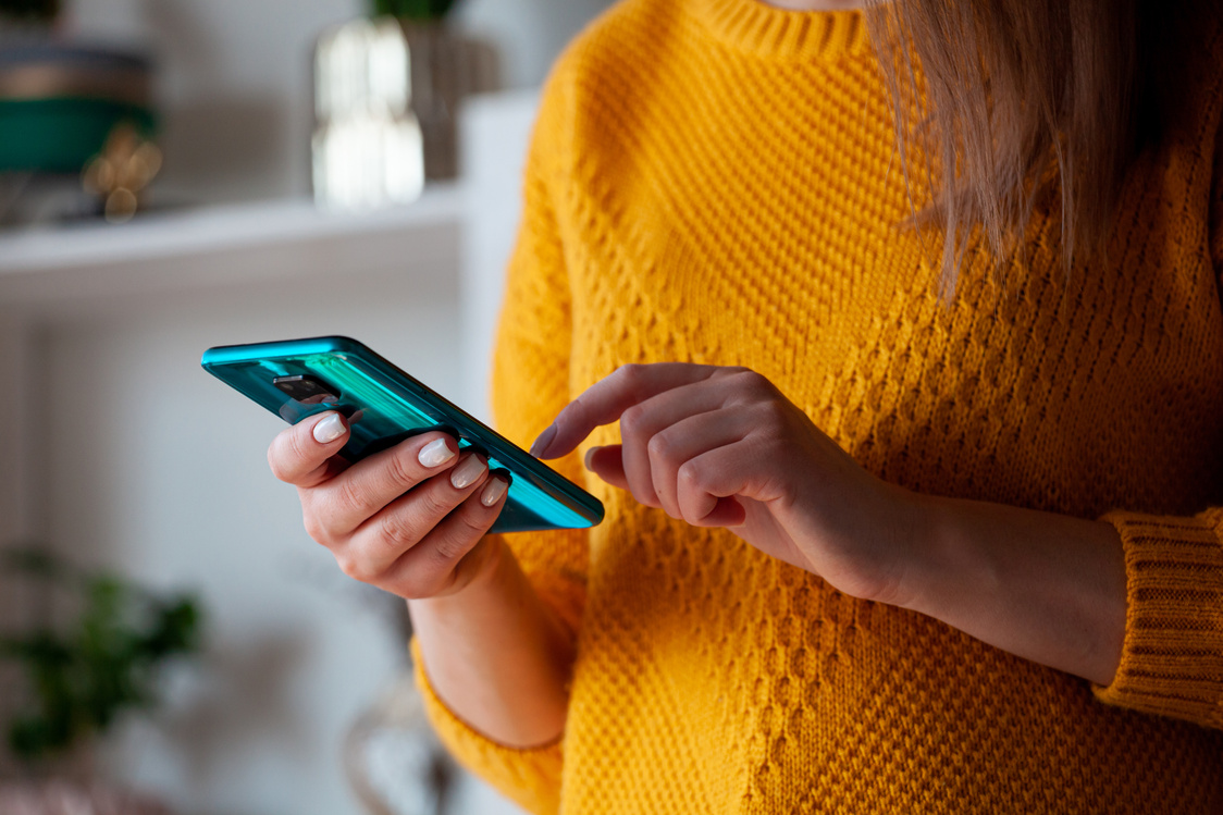 Woman using mobile phone, holding in hands